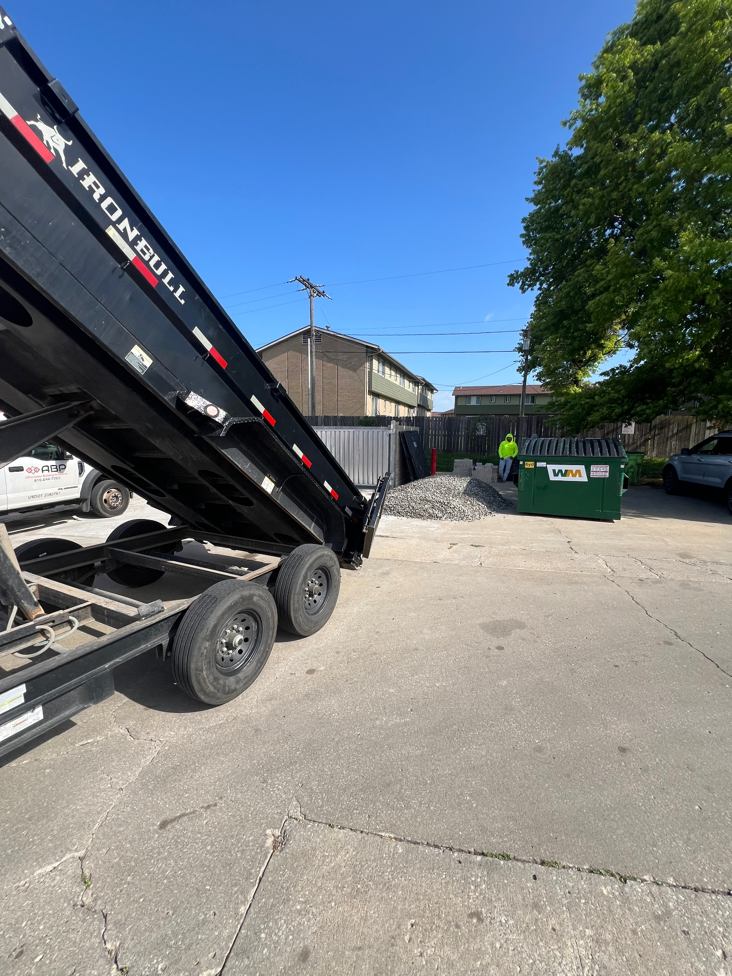 Dump trailer and materials staged for a Kansas City commercial landscaping and hardscaping project