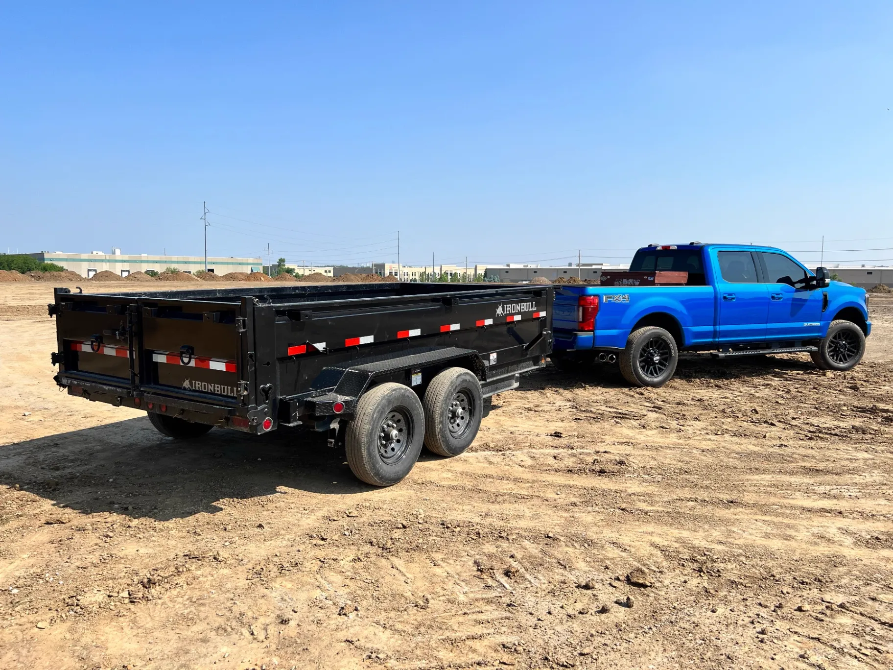 Juke KC professional blue Ford F-250 truck with Iron Bull dump trailer at commercial job site